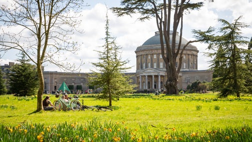 The Rotunda is viewed from across the North Lawn with daffodils in the foreground and a family enjoying time together
